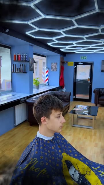 Junger Kunde mit Textured Crop im Salon mit blauen Wänden