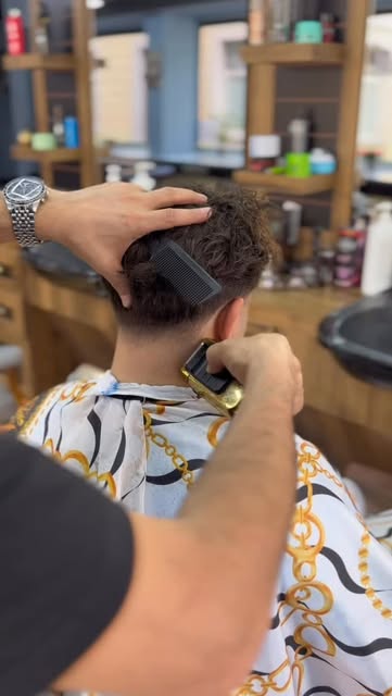 Barbier arbeitet mit dem Haarschneider an der Nackenkontur