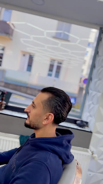 Kunde mit Vollbart in der Seitenansicht nach dem Schnitt